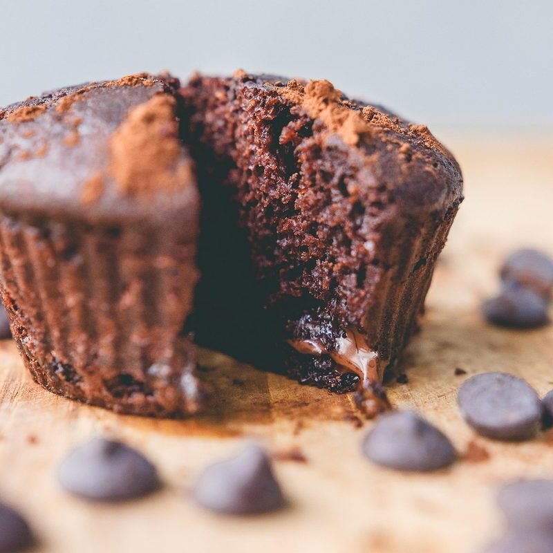 Chocolate muffin split open with melted chocolate center and chocolate chips